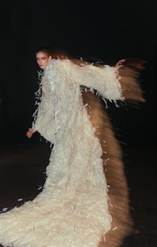 Artistic portrait of a model in a dramatic, flowing white gown with motion effect.