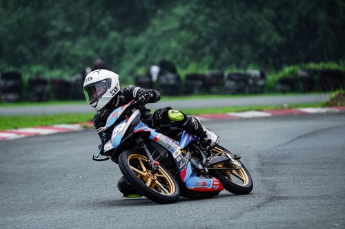 Free Motorbike racer leaning into a sharp turn at Tarlac City circuit, Philippines. Stock Photo