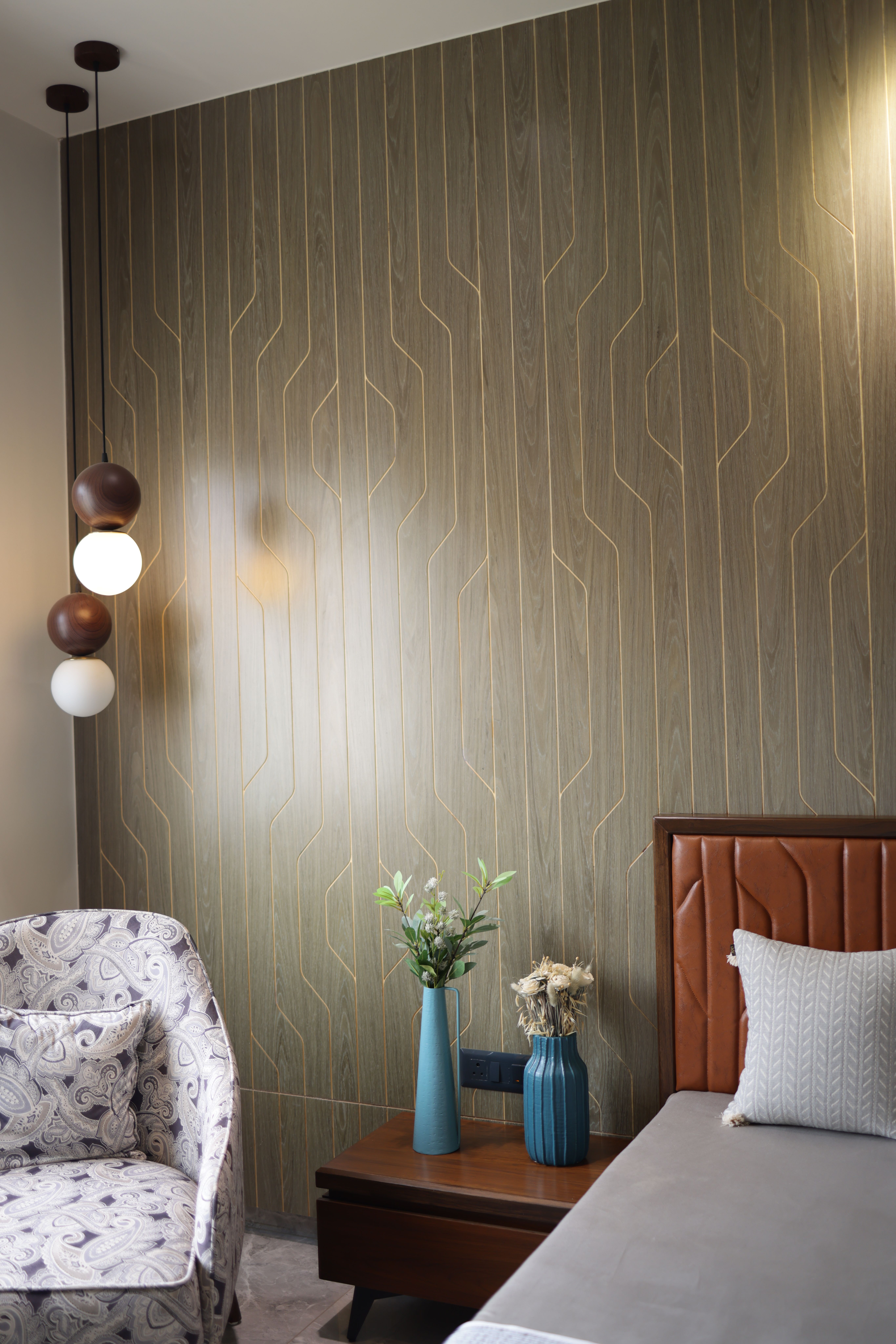 Stylish bedroom interior featuring wooden paneling, decorative lighting, and chic furniture.