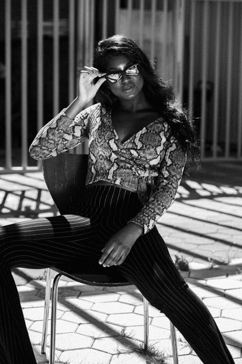 Greyscale Photo of Woman Sitting on Chair