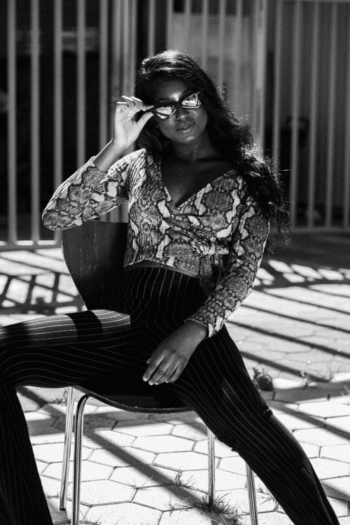 Free Black and white photo of a fashion model posing with sunglasses outdoors. Stock Photo