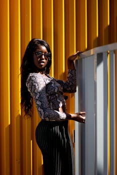 在充满活力的黄色背景下，时尚女性自信地摆出姿势