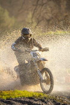 Dynamic shot of a motocross rider splashing through water on a sunny day.