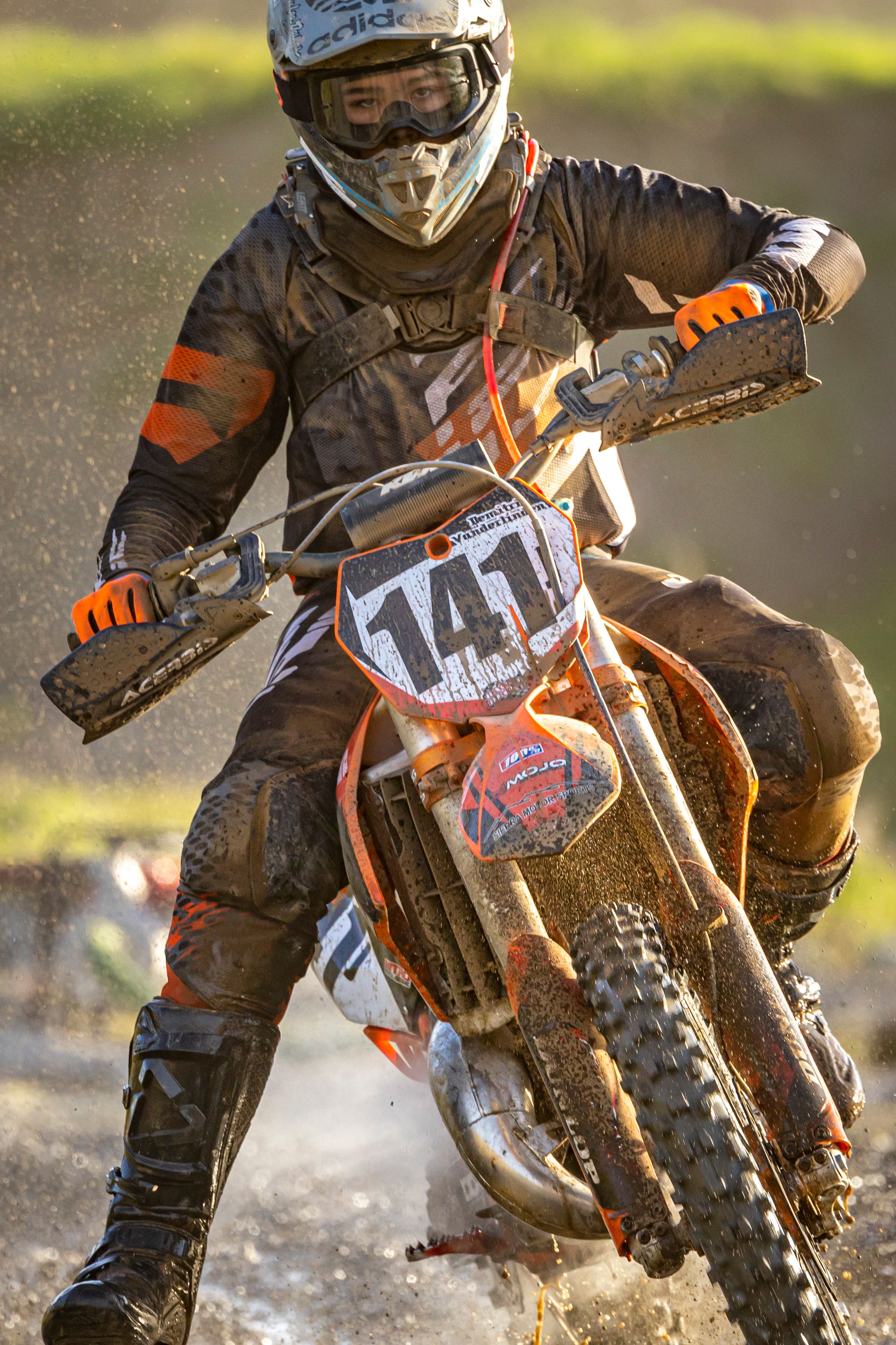 A thrilling image of a motocross rider speeding through a muddy track, capturing the intensity and excitement of the sport.