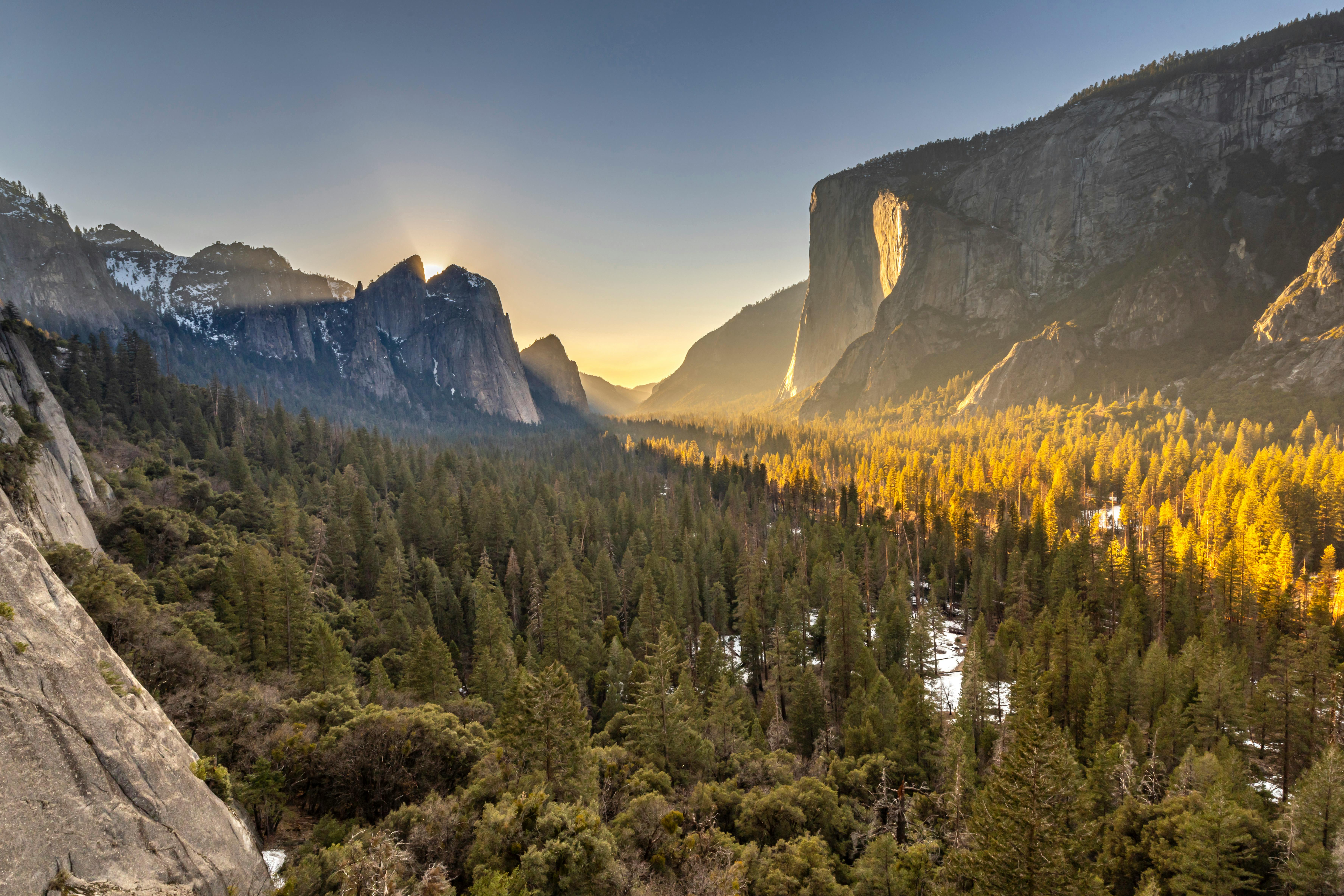 traveler watching sunset over preserved natural landscape - travel greener