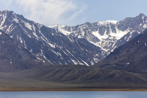 Free Stunning view of snow-capped mountains with a serene lake in the foreground under a clear sky. Stock Photo