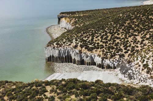 Free A stunning aerial view of rugged coastal cliffs with unique rock formations and lush vegetation. Stock Photo