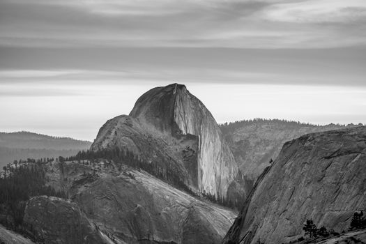 Black and white image featuring Half Dome in Yosemite National Park's mountainous landscape.