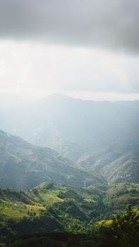 A stunning view of lush green mountains under a moody, overcast sky.