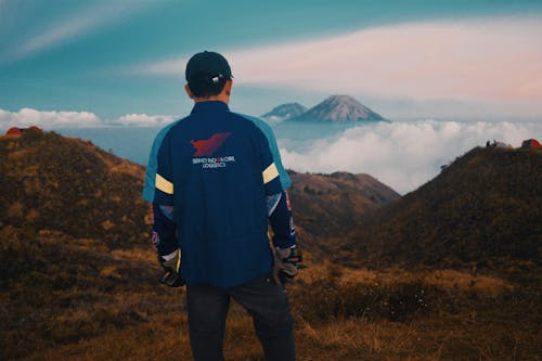 Pria Berdiri Menghadapi Gunung Di Atas Awan