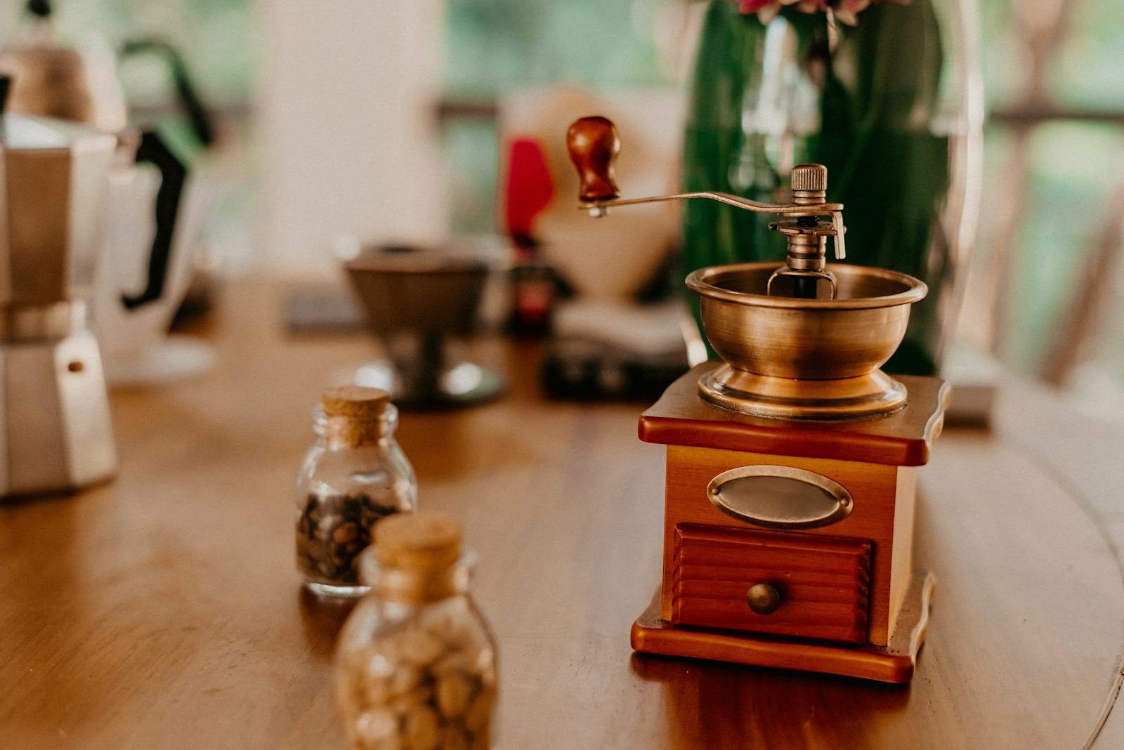 Antique wooden coffee grinder with hand crank on rustic table