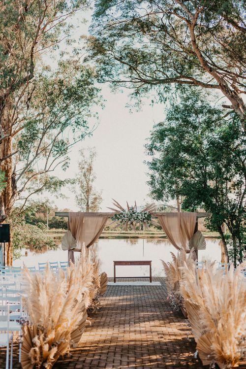 Free Charming outdoor wedding setup with rustic decor by a tranquil lake. Stock Photo