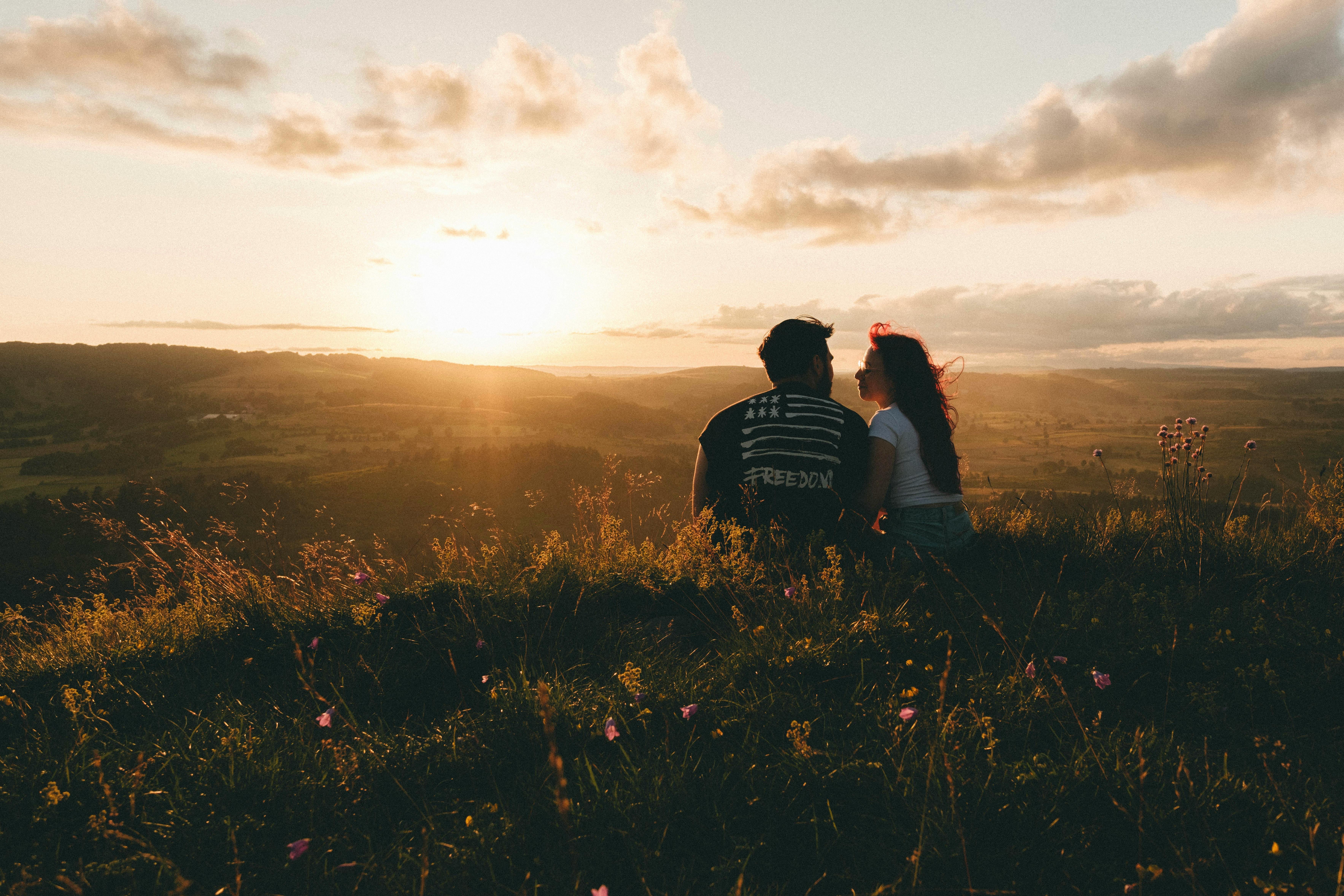 Free Couple enjoys a serene sunset in the beautiful Saint-Chély-d'Aubrac, France. Stock Photo