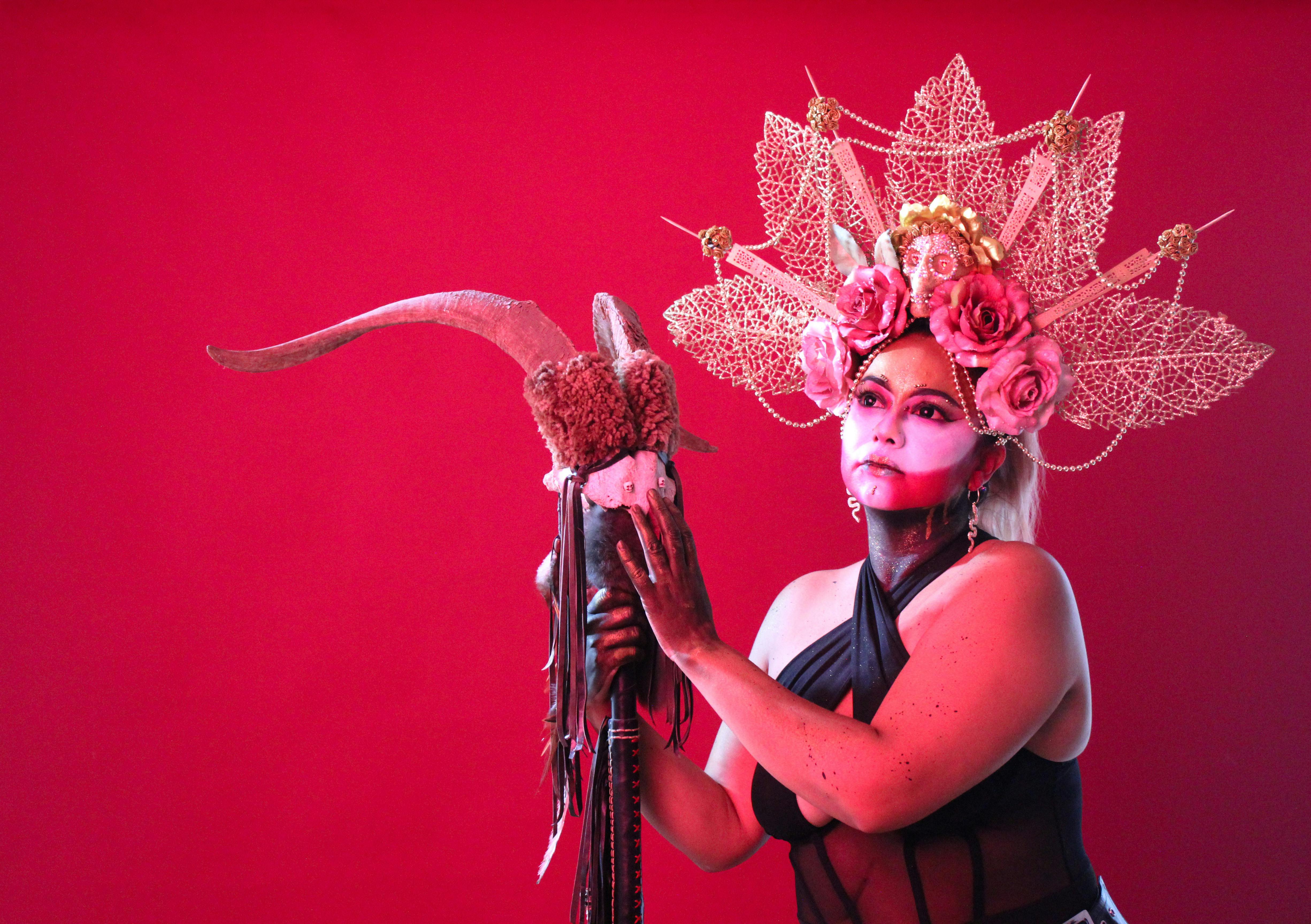 Free Artistic portrait of a person with a decorative headpiece against a red background, for conceptual photography. Stock Photo