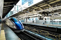 在繁忙的城市车站，时尚的子弹头列车飞驰而过，展现了速度与现代交通的魅力