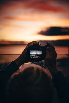 A DSLR camera captures the stunning sunset over Seattle's iconic waterfront scene.