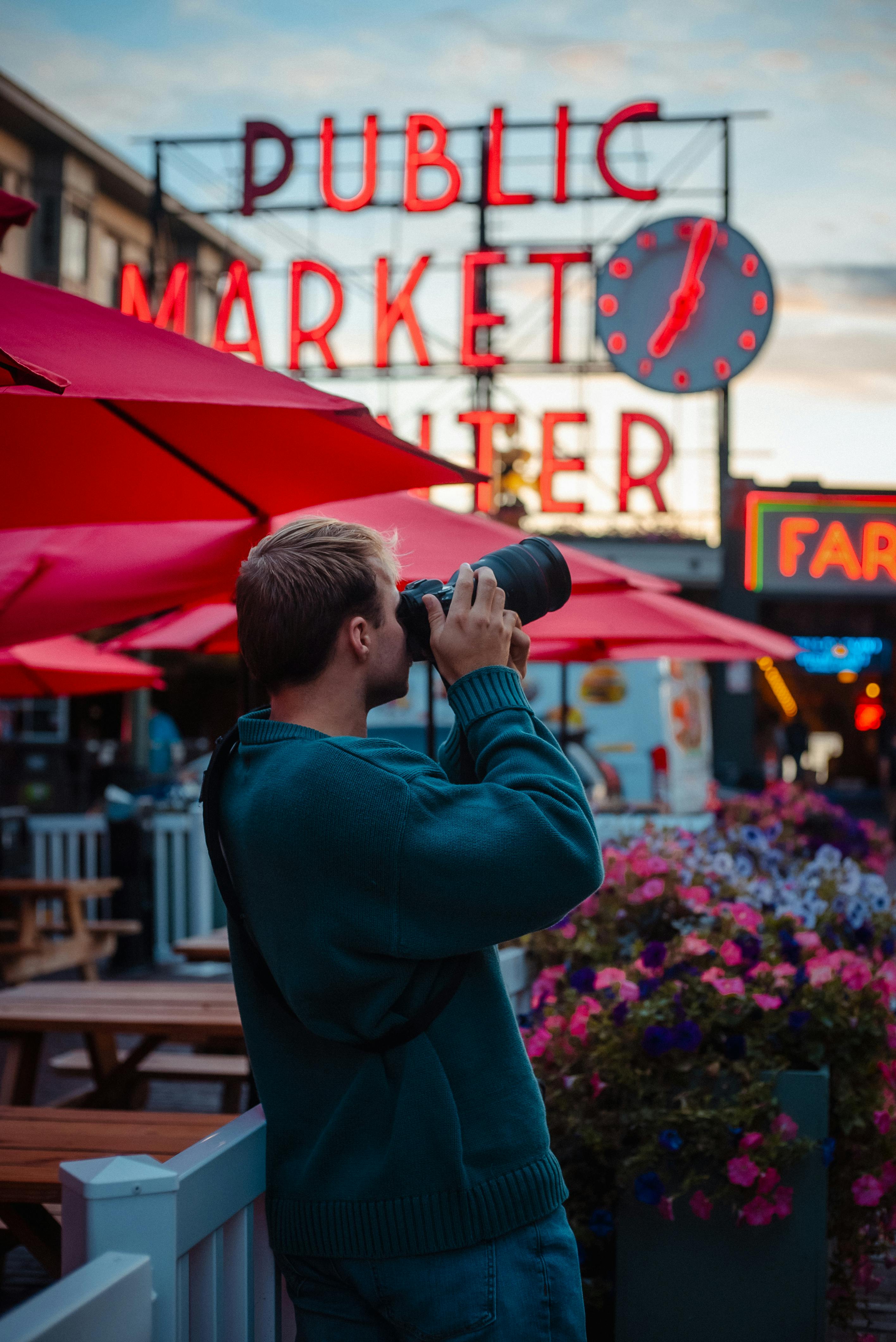 A photographer captures moments at Pike Place Market in Seattle during the day.