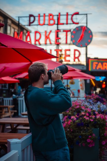 A photographer captures moments at Pike Place Market in Seattle during the day.