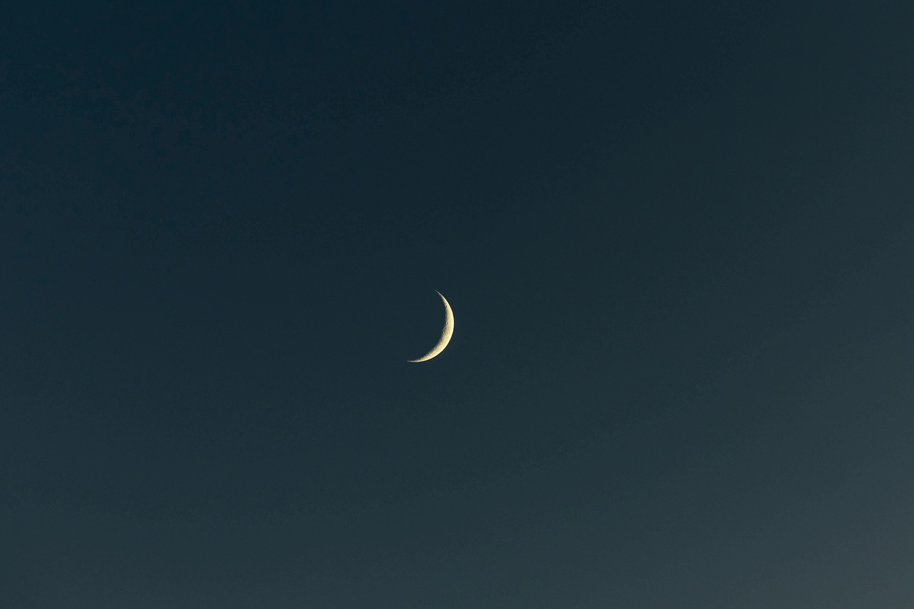 A serene view of a crescent moon against a dark night sky, ideal for backgrounds.