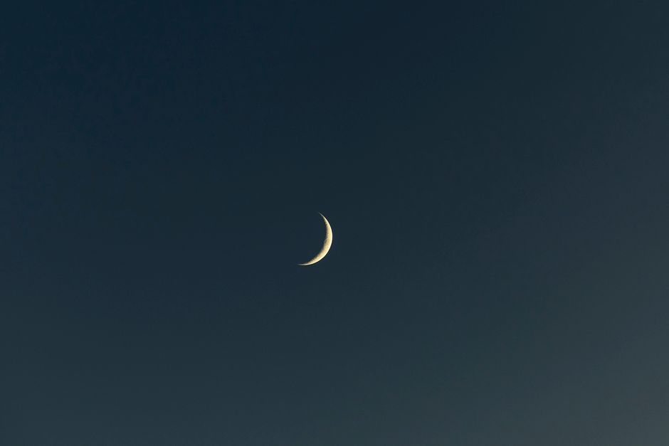 A serene view of a crescent moon against a dark night sky, ideal for backgrounds.