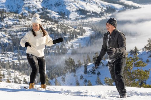 Free A joyful couple playing in the snow on a picturesque mountain in winter. Stock Photo