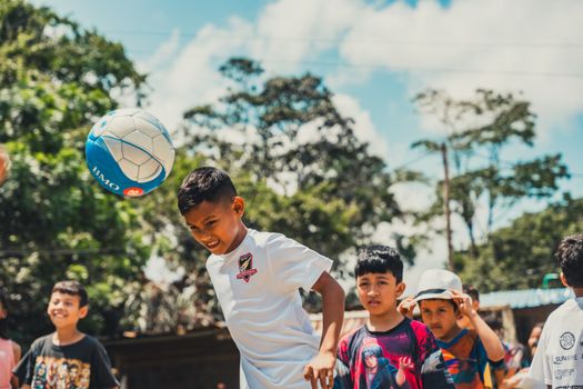 Group of kids enjoying a soccer game in the sun, surrounded by nature.