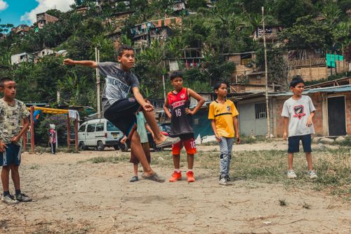 Free Group of boys enjoying a soccer game outdoors in a rural neighborhood. Stock Photo