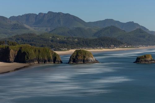 Free A breathtaking view of a serene coastline with sea stacks and lush mountains. Stock Photo