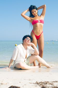 Two friends enjoy a sunny day on a tropical beach, posing for a fun vacation photo.
