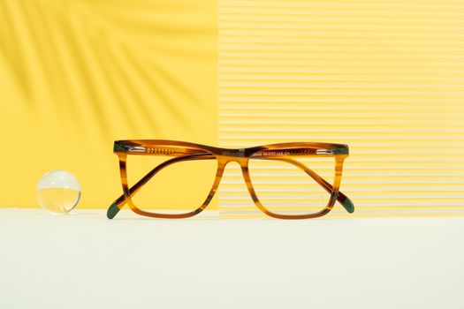 Elegant eyeglasses displayed on a vibrant yellow background with modern aesthetic appeal.