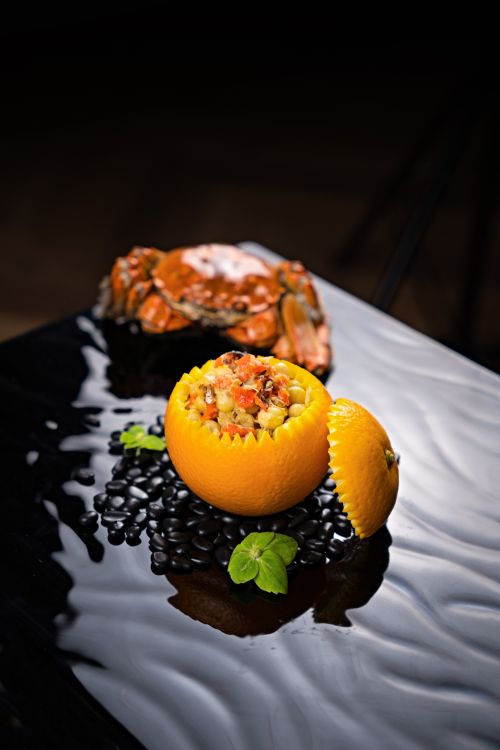 Free Exquisite crab dish served in an orange, elegantly plated on dark reflective surface. Stock Photo