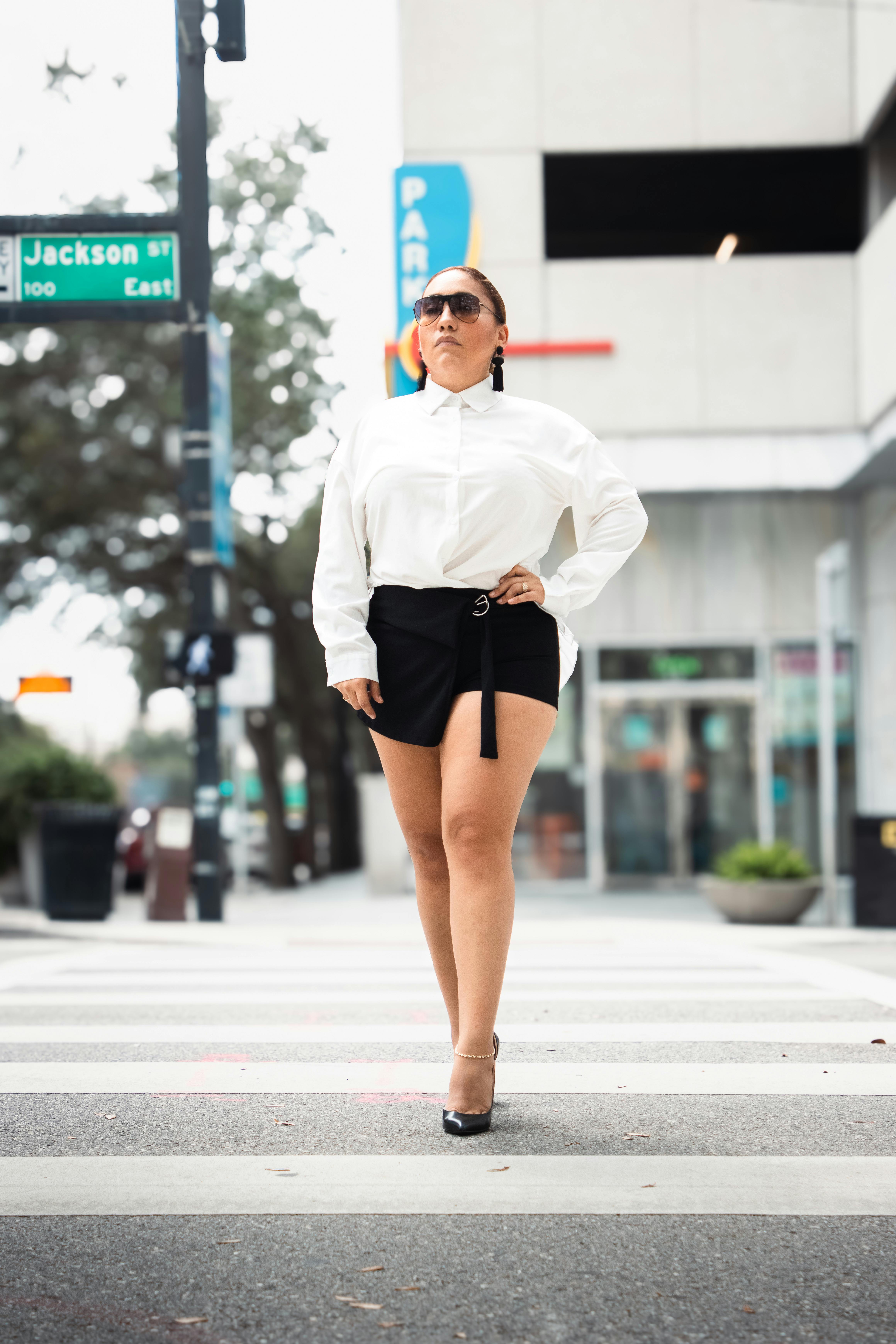Stylish woman crossing street in city, exuding confidence.