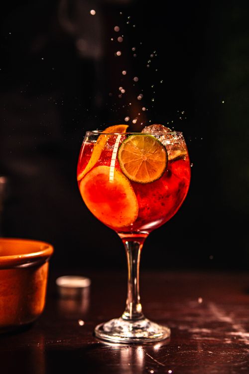 Free Vibrant cocktail with citrus slices creating a splash effect, perfect for a lively atmosphere. Stock Photo