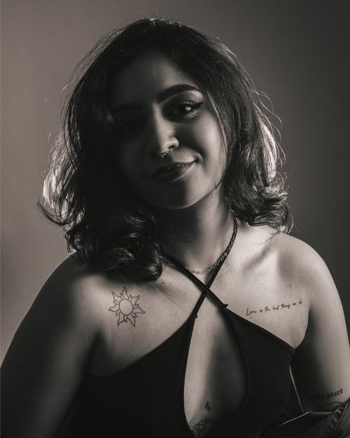 Free Elegant black and white portrait of a woman with tattoos, showcasing a relaxed and confident pose. Stock Photo