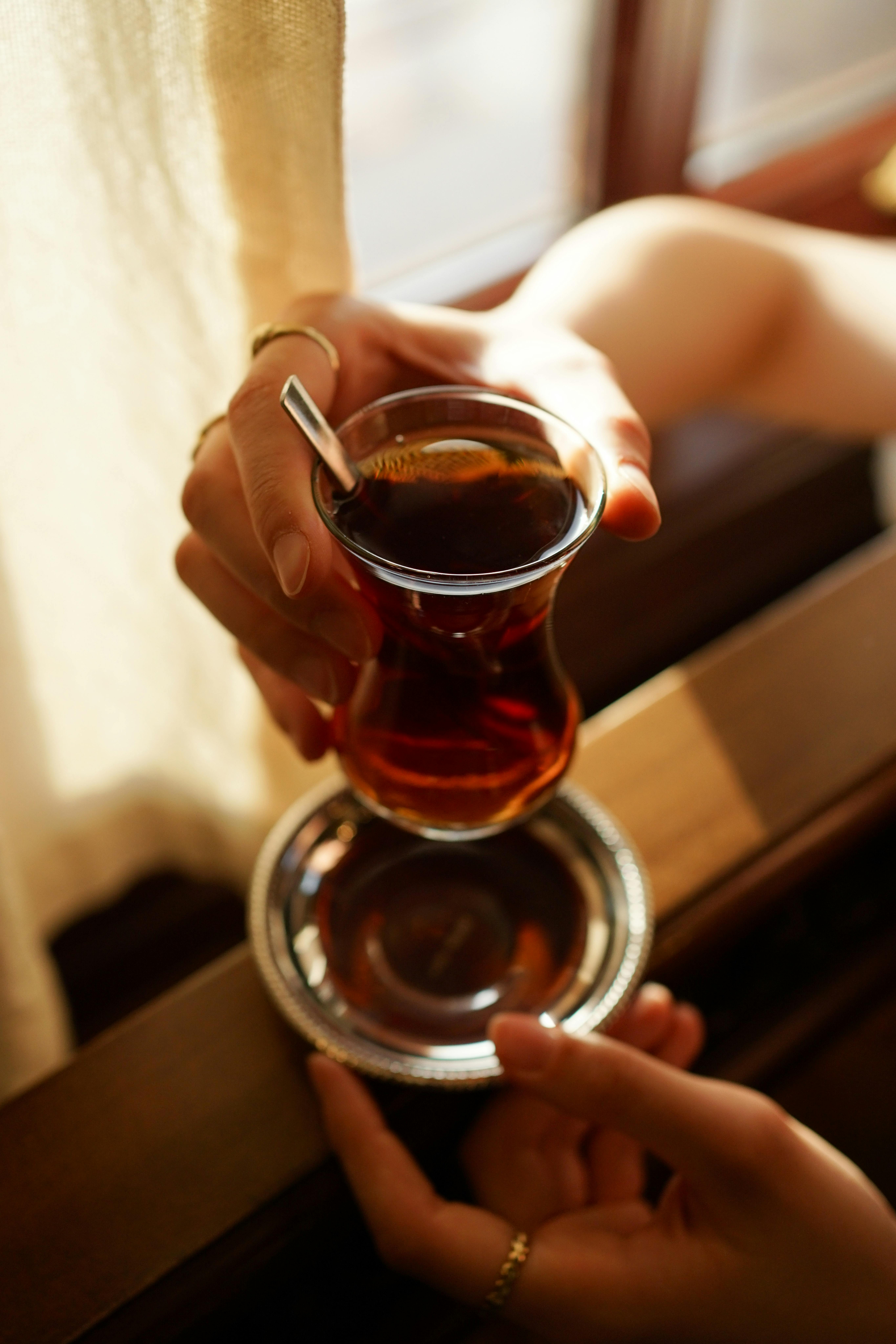 Close-up of Turkish tea in a traditional glass on a tray. Warm lighting enhances the mood.