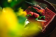 特写镜头中，一个浓郁的红色天鹅绒蛋糕上撒着新鲜草莓和奶油奶酪糖霜