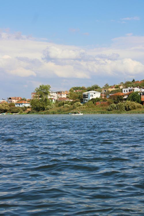 Free Scenic view of a tranquil lake with a small village in the background. Stock Photo