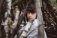 一个生活在质朴木结构森林环境中的孩子，深思熟虑