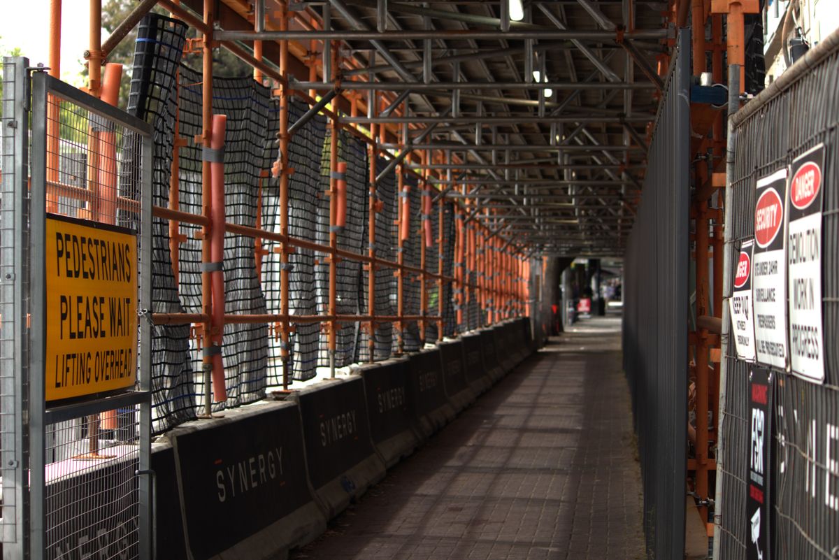 Temporary fencing and hoarding protecting a pedestrian walkway at a Hamilton construction site