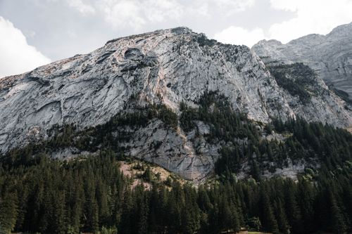 Free Scenic view of Mont-Saxonnex's towering rock formations and lush forests under a bright sky. Stock Photo