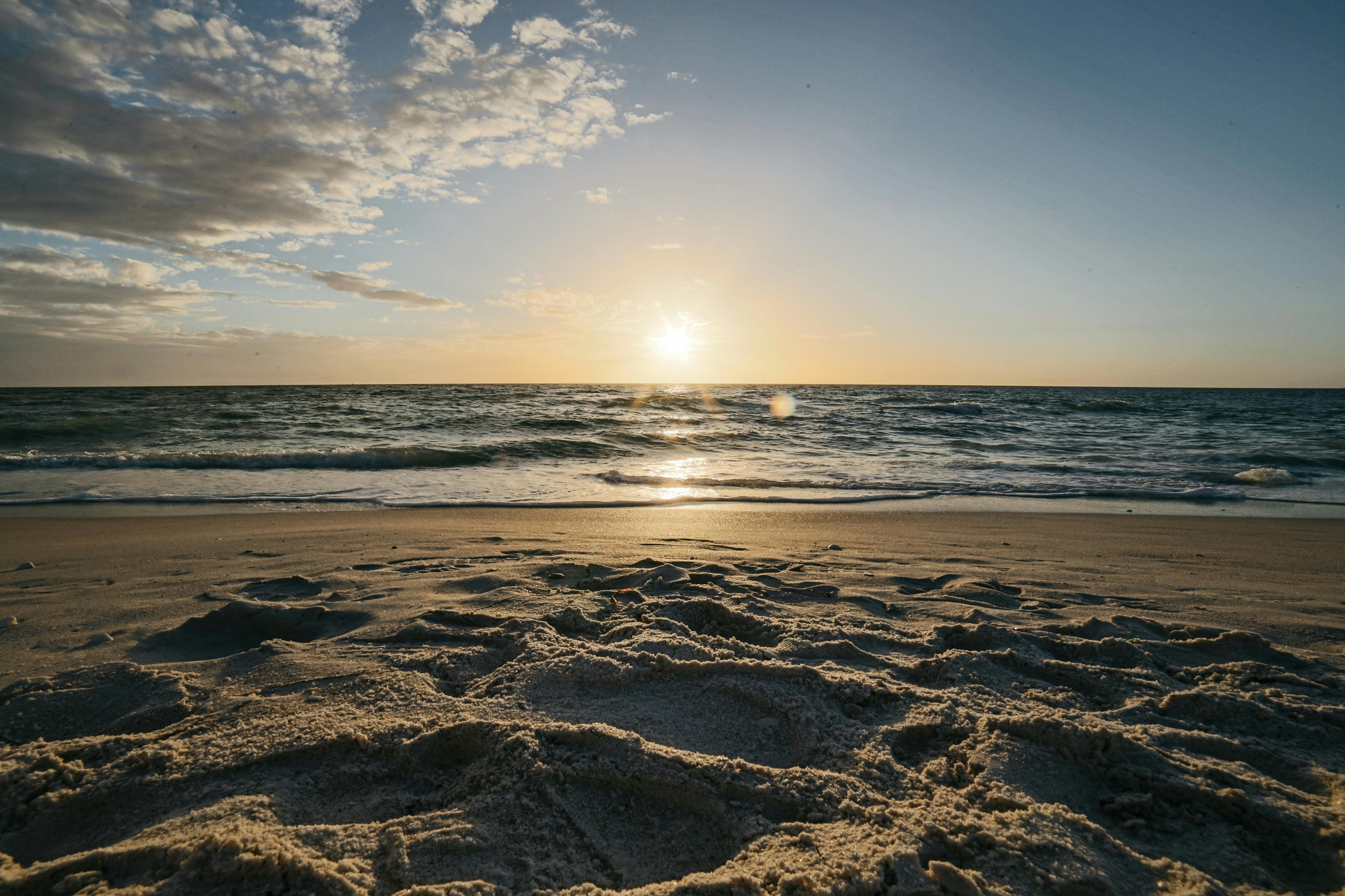 宁静的日落映照着沙滩和温柔的海浪，捕捉了海景的静谧