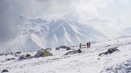 Free Hikers enjoy a breathtaking winter trek through snow-covered peaks in Kashmir, India. Stock Photo