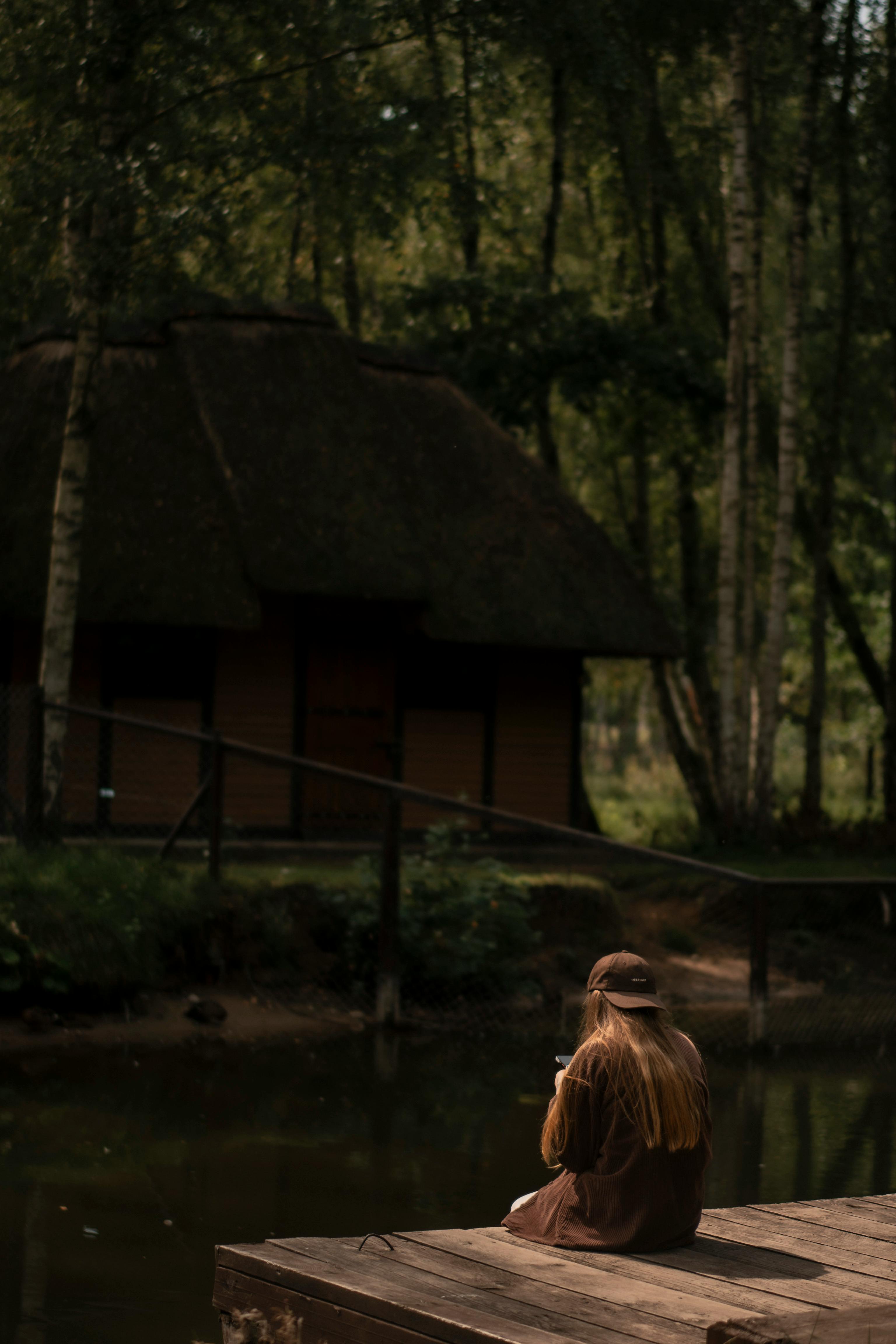 Woman in tranquil nature retreat, serene and surrendered, evoking the soft morning aftermath and lingering peace