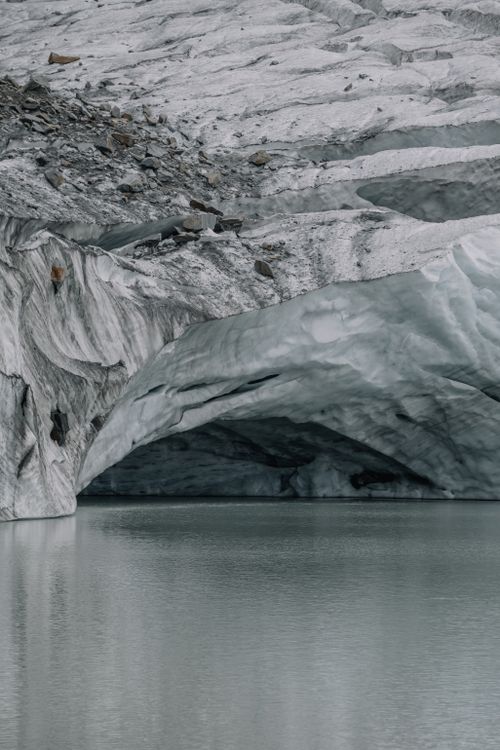 Free Stunning view of a glacier's icy structure reflected on a serene water body. Nature's wonder. Stock Photo