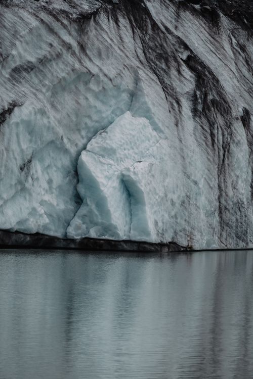 Free Dramatic glacier wall mirrored in a calm lake, capturing natural beauty and serenity. Stock Photo