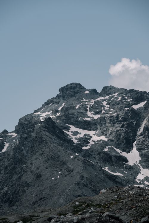 Free A stunning view of a snow-capped mountain range against a clear blue sky, showcasing rugged beauty. Stock Photo