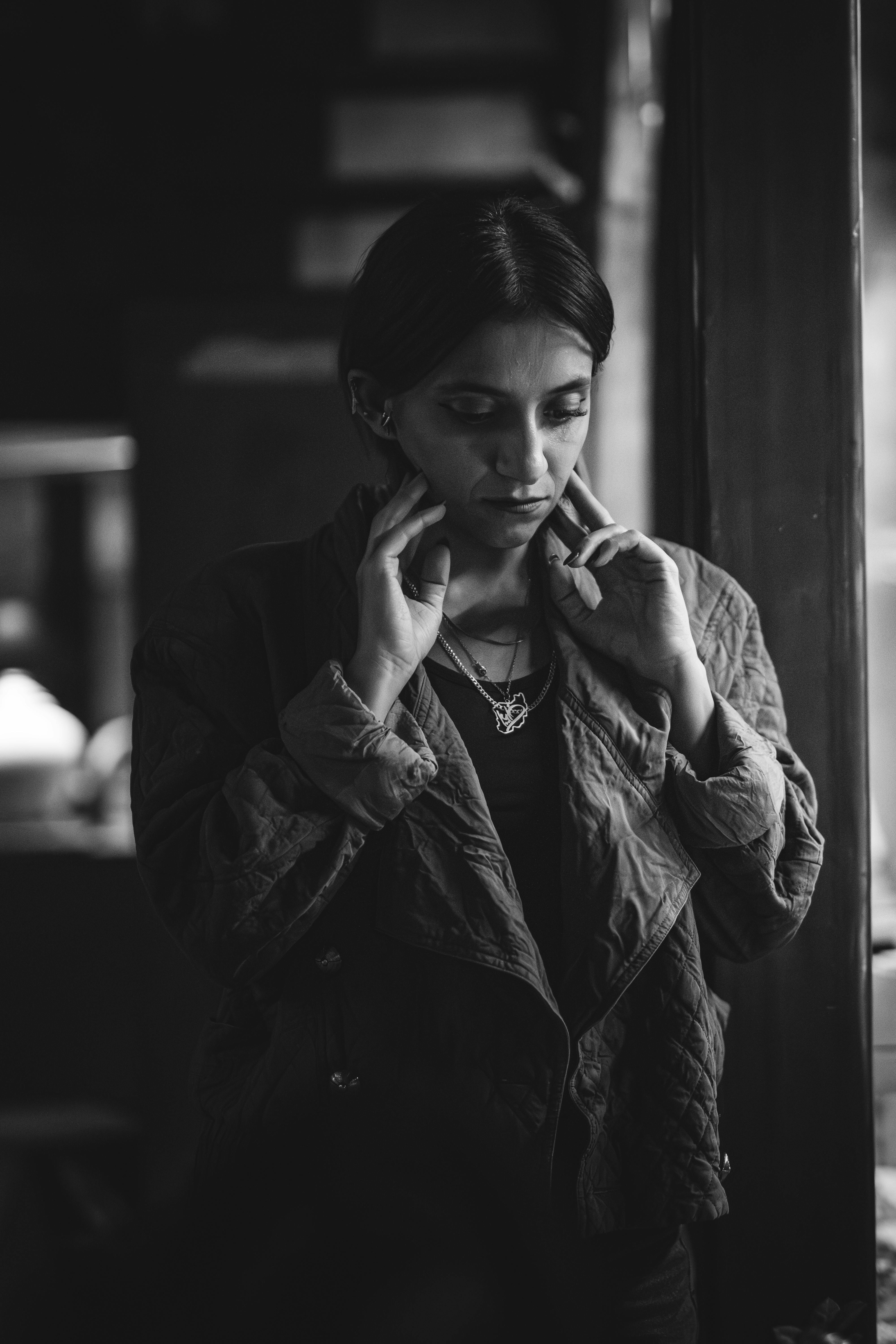 Free Moody black and white portrait of a young woman expressing introspection indoors. Stock Photo