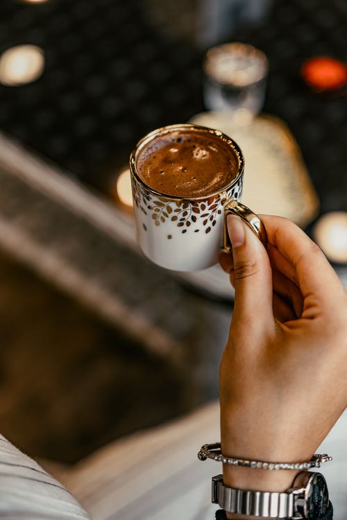 Free A person holding an ornate coffee cup indoors, creating a cozy atmosphere. Stock Photo