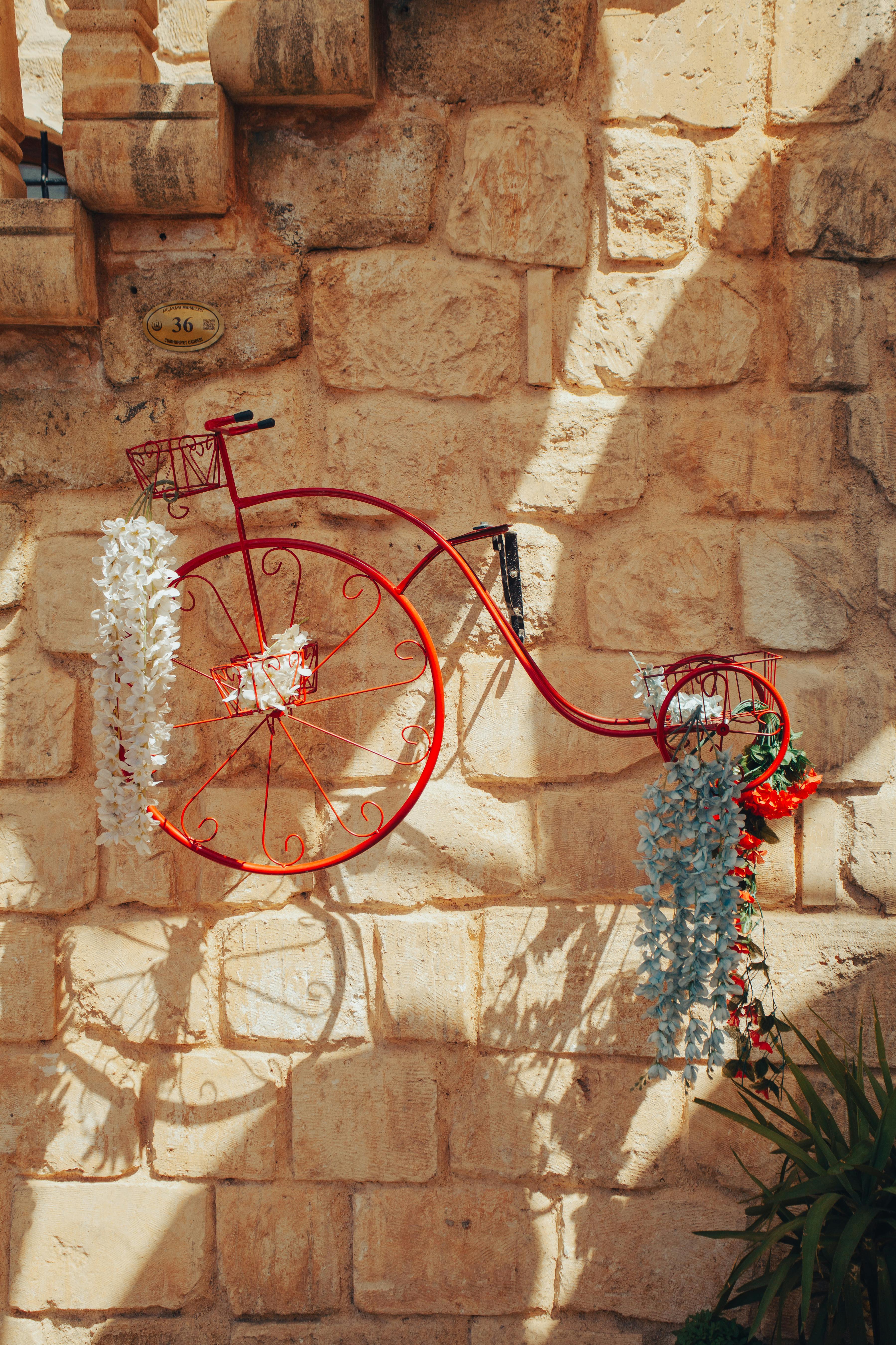Colorful bicycle art decorates a historic stone wall in Mardin, creating a vibrant street scene.