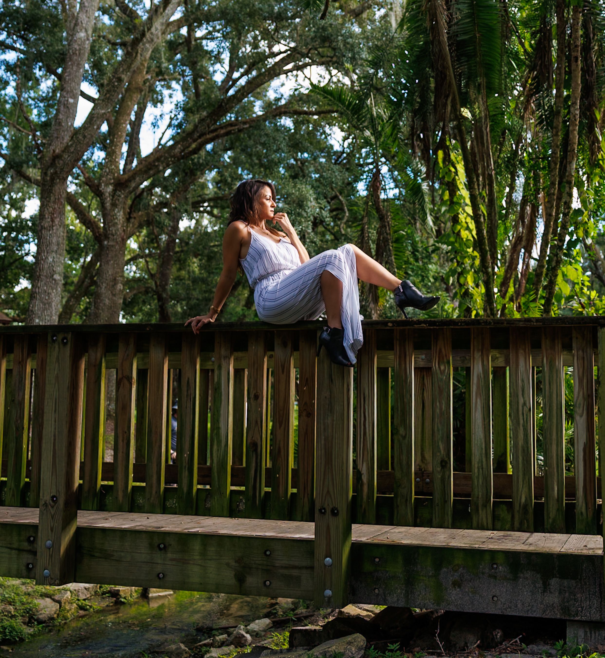 Woman Relaxing on Wooden Bridge in Lush Forest · Free Stock Photo